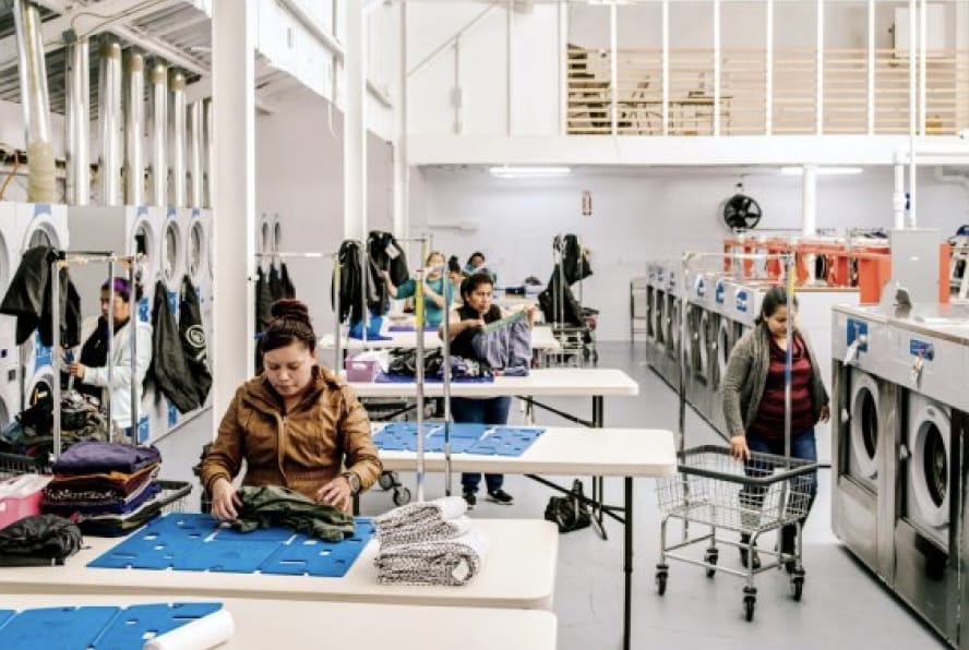 Employees of a Rinse cleaning partner folding laundry